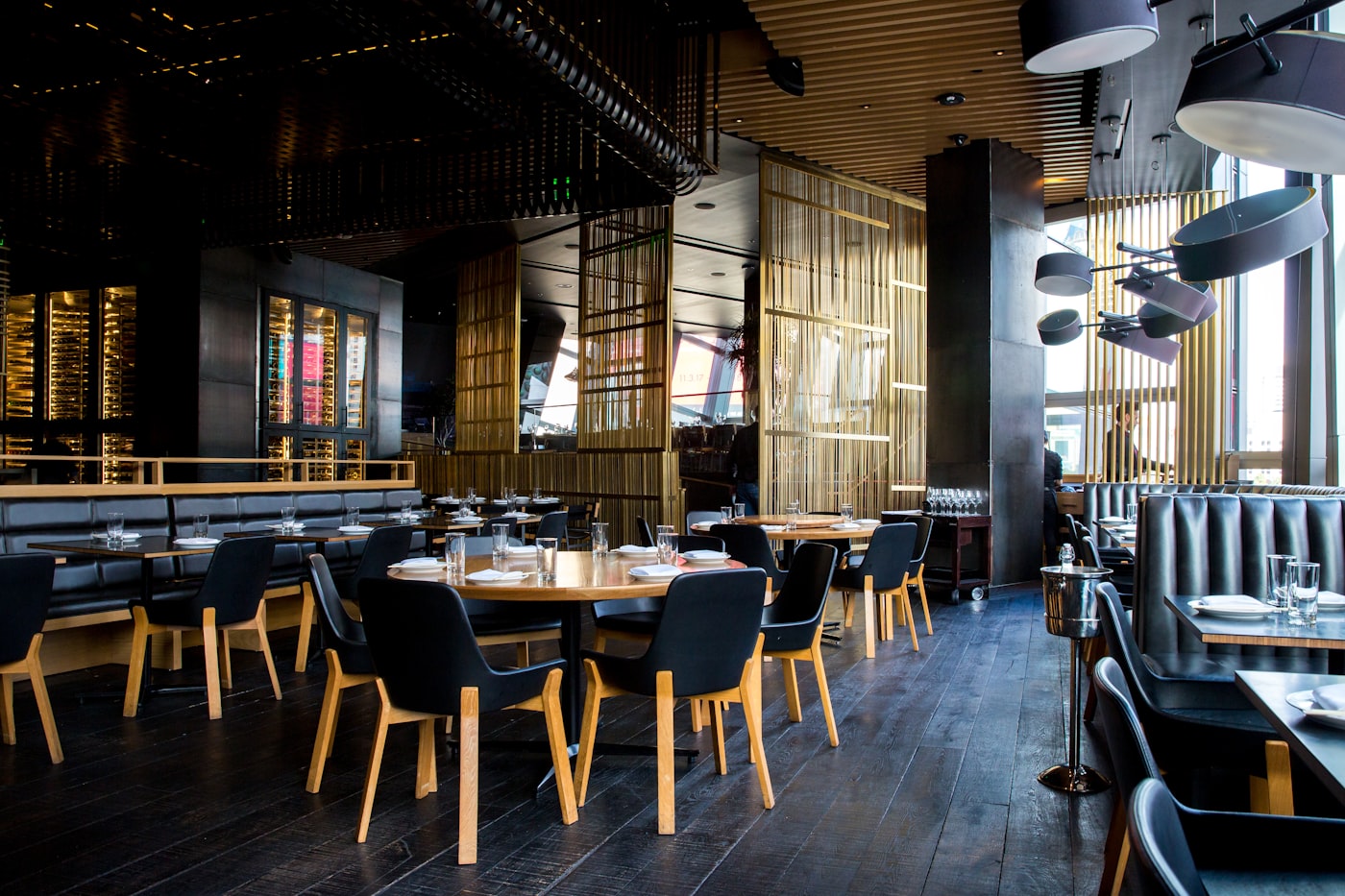 Comedor de restaurante de hotel con mesas de madera preparadas y luz cálida