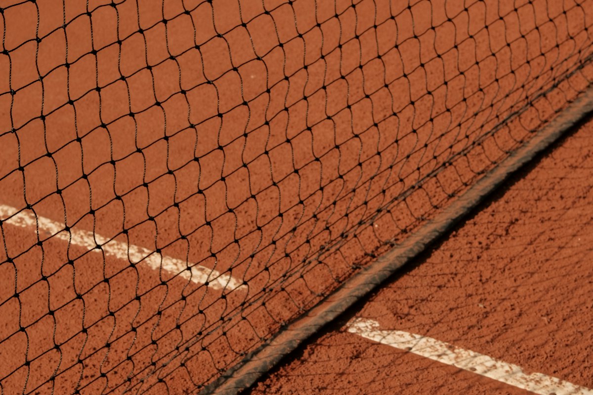 Detalle de la red y la tierra batida de una pista de tenis